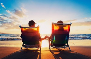 senior couple of old man and woman sitting on the beach watching