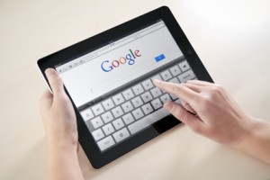 Kiev, Ukraine - December 03, 2011: Woman hands holding and touching on Apple iPad2 with Google search web page on a screen.