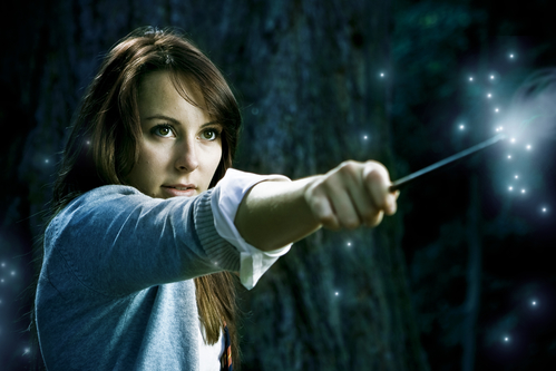 Teenage wizard girl with magic wand casting spells in a enchanted fantasy forest
