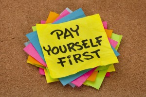 pay yourself first, a reminder of personal finance strategy - stack of colorful sticky notes on a cork bulletin board