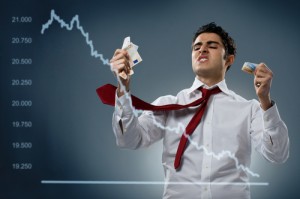 Young businessman getting mad behind a declining share. Recession and crisis concept!