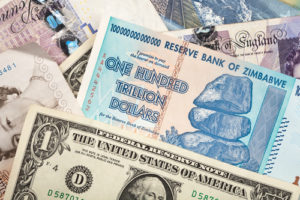 Money background with US dollars, British pounds, Lithuanian litas and Zimbabwe hundred trillion dollars