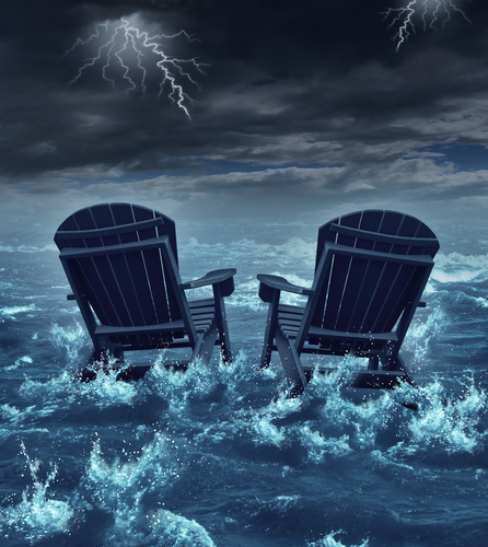 Retirement crisis concept as a couple of adirondack chairs sinking in the ocean during a thunder storm as a metaphor for financial investment problems for retiring seniors who lost their savings or broken dreams symbol.