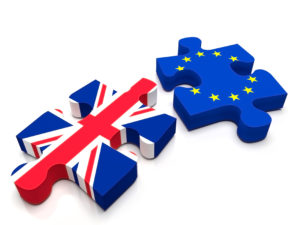 2 puzzle pieces: One containing the British Flag and the other the European Union / EU flag. Is UK leaving Europe with the BREXIT?