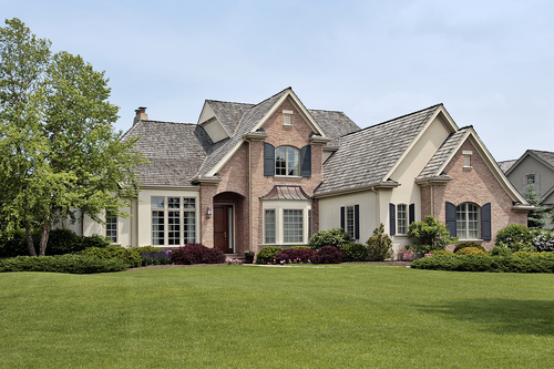 Large luxury brick home in suburban setting