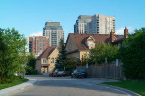 Quiet street with new houses and condo buildings on the background.