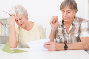 Senior Couple Were Disappointed While Reading Letter On Table